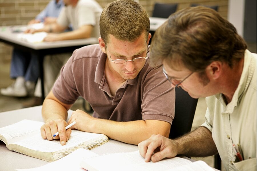 Instructor and fabricator student sit at a desk with the first one delivering a theoretical training course to the second one based on the Technical Training program