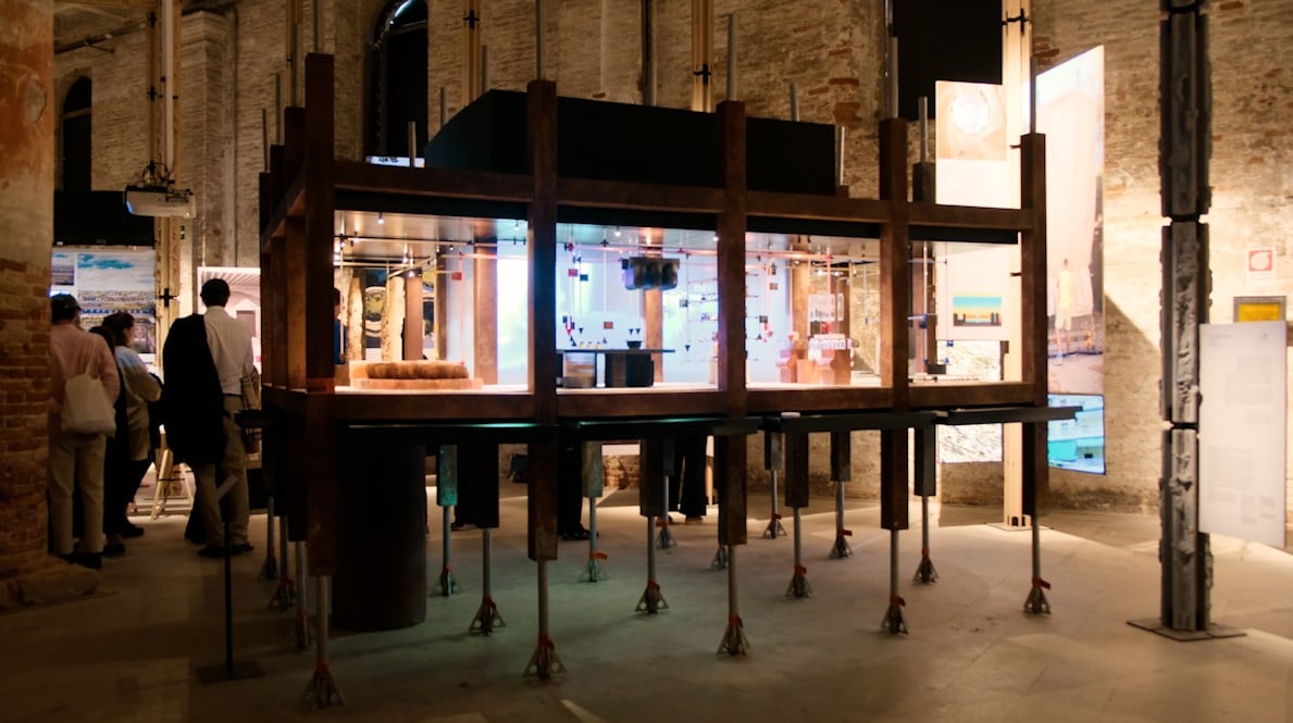 Metabolic Home Biennale 2025 Architectural exhibition with an exhibit and people looking at it