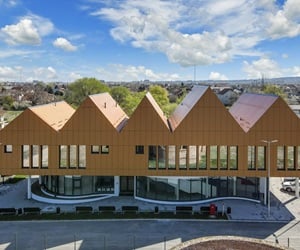 The ground floor is curved and is covered with curtain walls, the first floor is covered with cladding and has large windows