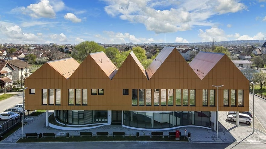 The ground floor is curved and is covered with curtain walls, the first floor is covered with cladding and has large windows