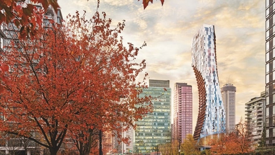 The tower in between other buildings and trees with red leaves