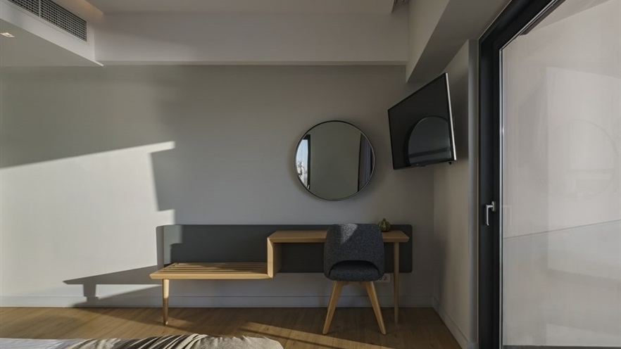 Desk with chair and mirror, large TV hanging on the wall