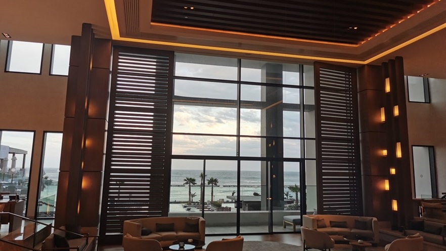 Large glass openings give a view from the lobby to the sea