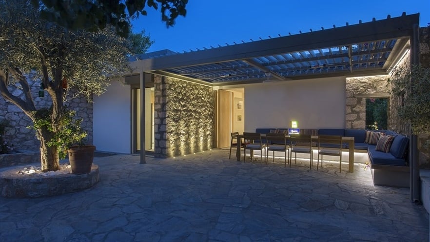 Outdoor sitting area under a pergola at night