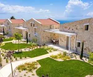 Four stone houses that have a front terrace and access to a garden