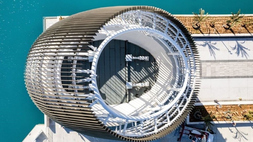 The building has a large metal struture around it, holding the curtain walls and the louvers