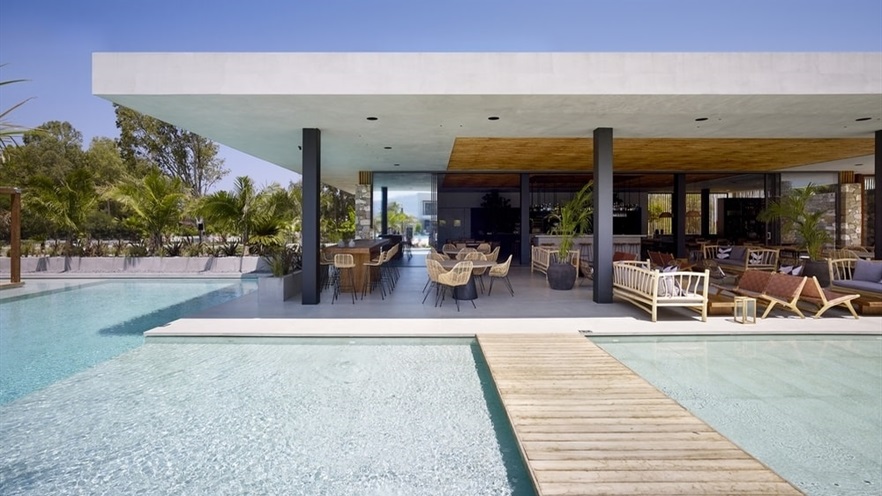 A path on top of the pool, leading to the outdoor area with chairs and sofas