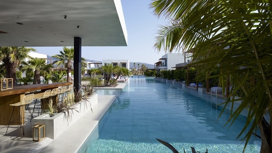 Pool and sitting area with a bar and stools, and lots of plants