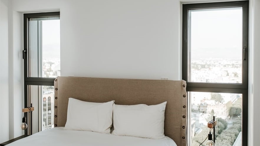 Bedroom with aluminum windows at each side of the bed