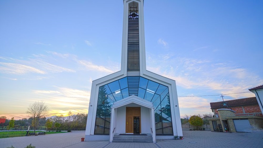 The church is minimal with a tall bell tower