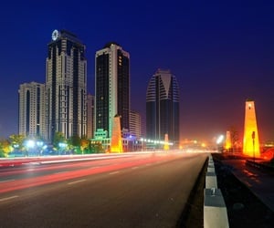 The street next to the buildings with traffic at night