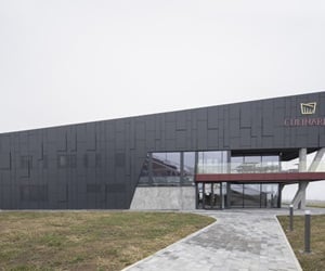 The building is covered in cladding and is surrounded by a big garden