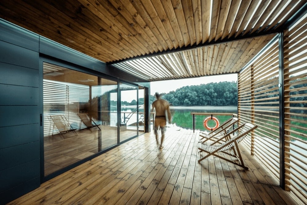 A guy walks through the enclosed terrace with the pergola and the open aluminum window