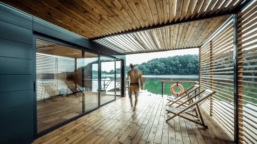 A guy walks through the enclosed terrace with the pergola and the open aluminum window