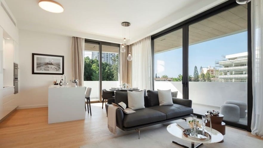 The living area includes a kitchen and a sitting area with large windows
