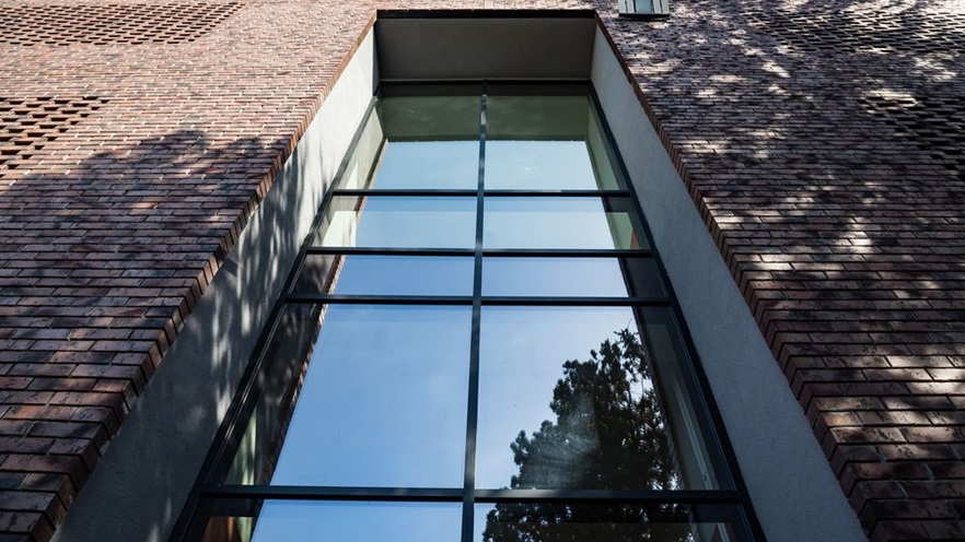 There is a tall curtain wall in one side of the building