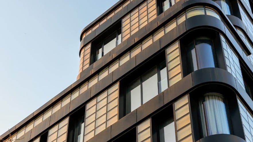 Golden Reflection building balconies with glass railings and aluminum windows, featuring yellow-tinted glass panels