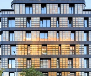 Façade of Golden Reflection building featuring a grid-like pattern of aluminum curtain walls and balconies with glass railings