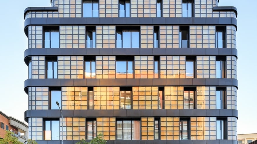 Façade of Golden Reflection building featuring a grid-like pattern of aluminum curtain walls and balconies with glass railings