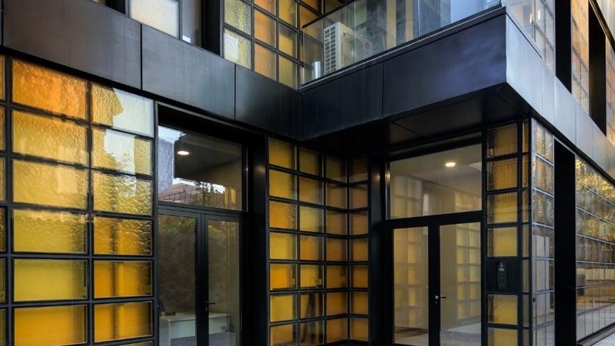 Detail of Golden Reflection building showcasing balconies with transparent glass railing and aluminum doorss