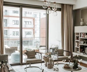 Living room in neutral tones, with a view to the building across the street