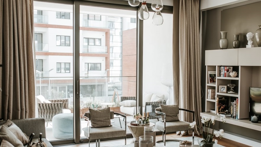 Living room in neutral tones, with a view to the building across the street