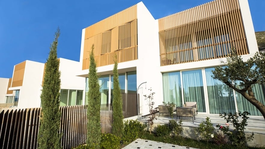 The house has an outdoor sitting area with trees