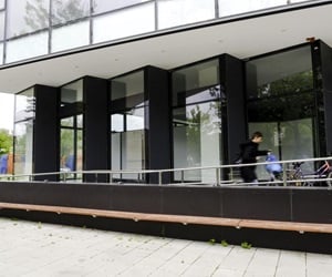 The ground floor is enclosed with curtain walls that are not in a straight line, but create corners