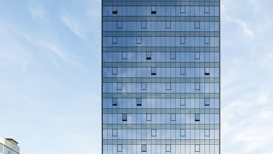 The curtain wall at the front of the building has some open windows