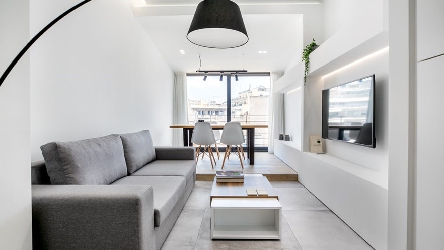 The living room contains a couch, a wall-mounted TV and a dining table