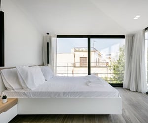 The bedroom has large windows on two sides