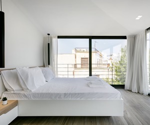 The bedroom has large windows on two sides