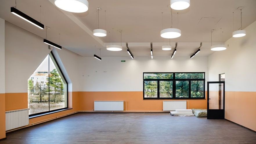 A large empty room with multiple windows and lights