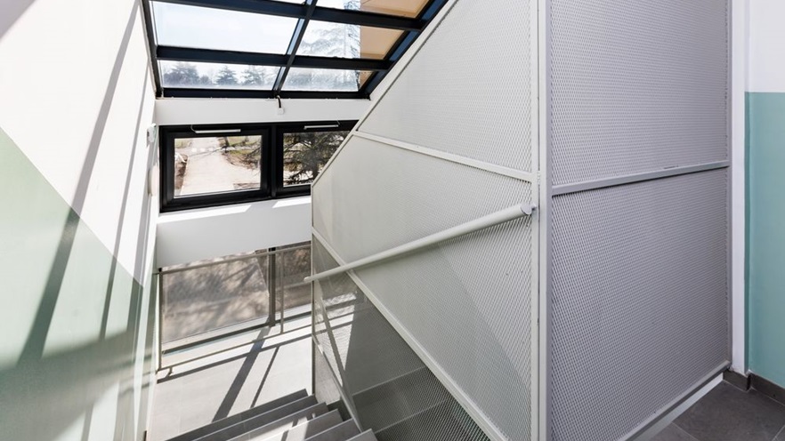 The staircase is sunny thanks to the large window openings
