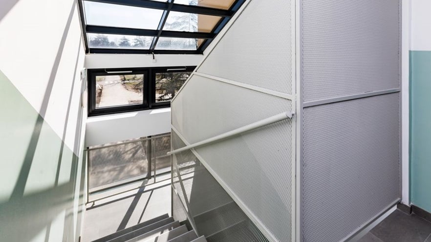 The staircase is sunny thanks to the large window openings