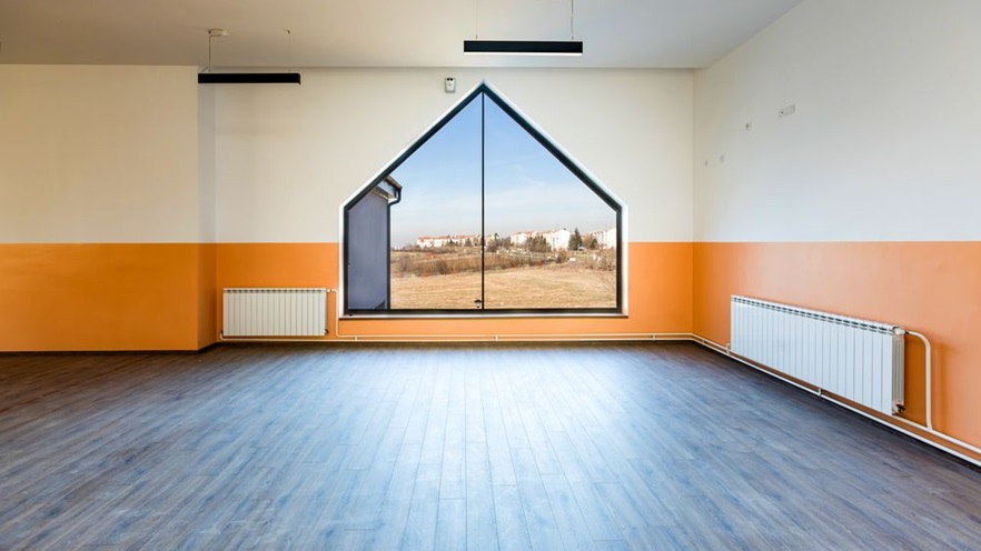 The house-shaped window offers a view to a large field