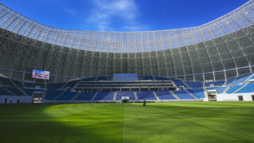 Grass and stadium stands with screen above