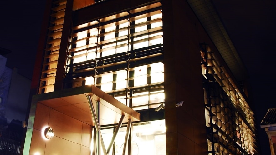 The building entrance at night with lights on