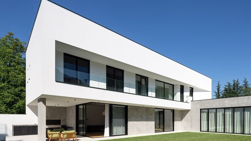 The house has a terrace at the ground floor and a large balcony on the top floor.