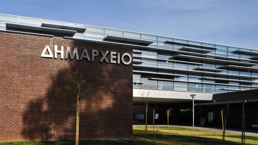 City hall sign on the brick wall with the glass façade and the aluminum shading systems in the back