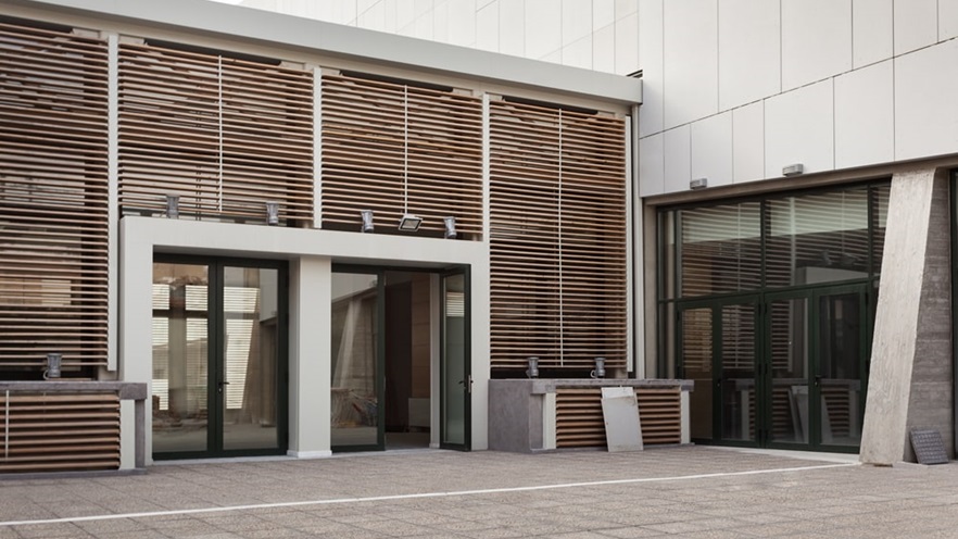 The building entrance has wooden shading around the two doors