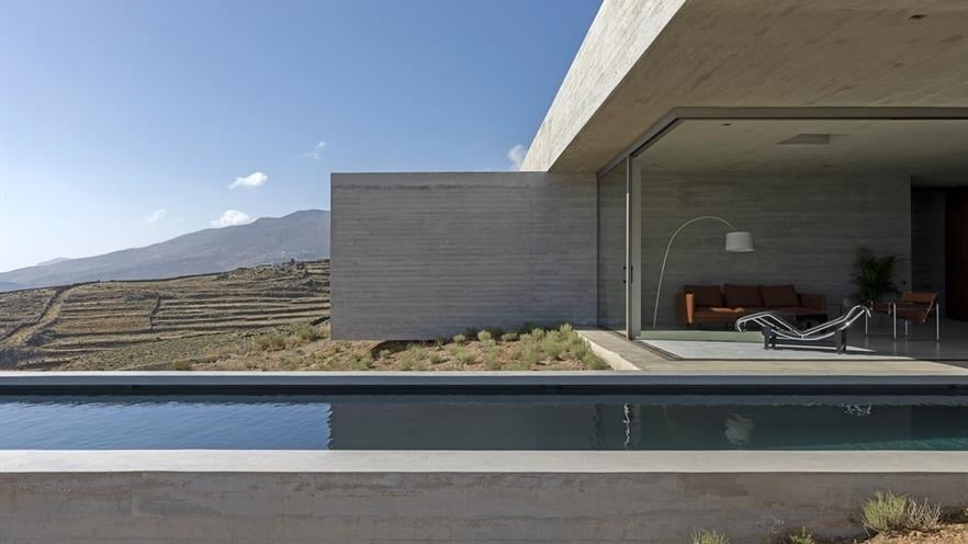 Pool with living room and concrete wall in the back