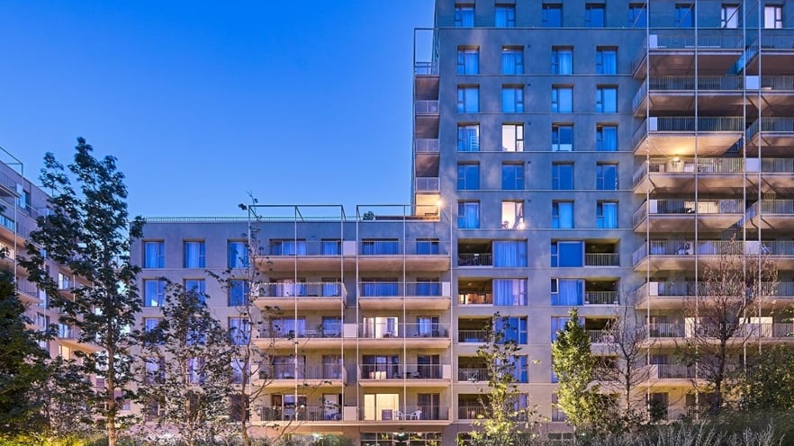 Close-up of Marmura Residence façade showing large aluminum-framed windows, glass balconies, and a color palette of tan, green, and gray with clean, modern lines