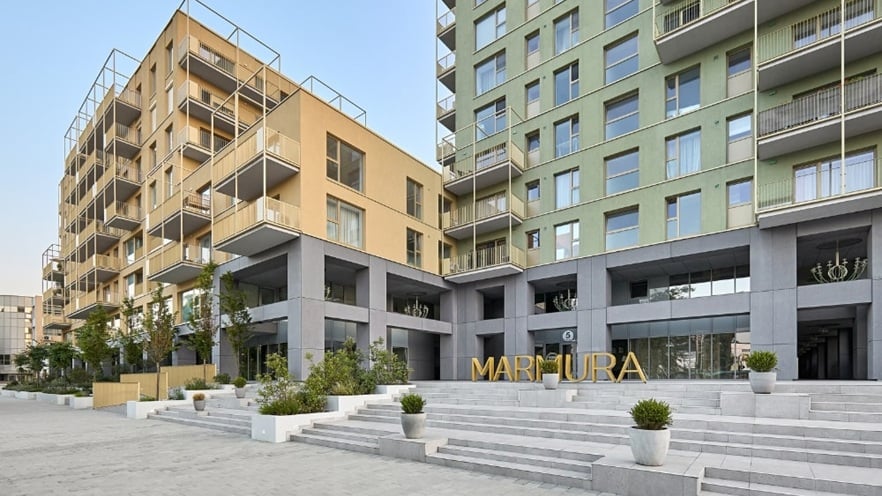 Entrance area of Marmura Residence with wide concrete stairs, minimalist planters with greenery, and a modern façade featuring clean lines and muted tones