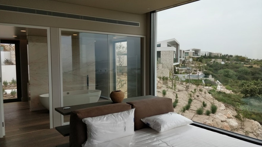 The master bedroom has large glass openings on every side, one of them highlights the bathtub
