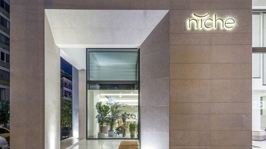 The hotel's entrance with concrete and glass