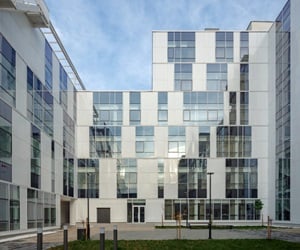 The building has many windows and glass curtain wall that overlook the courtyard
