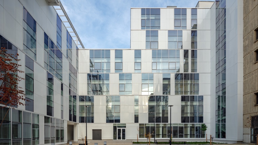 The building has many windows and glass curtain wall that overlook the courtyard