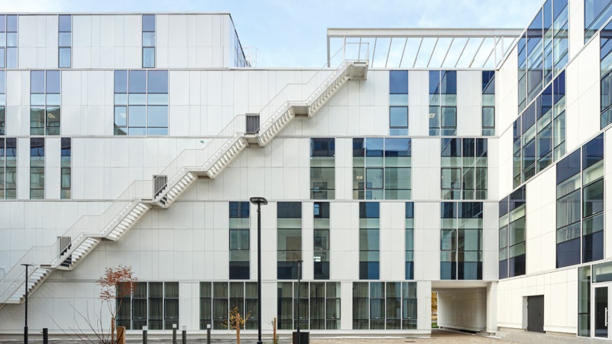 The building's façade has pieces of cladding and curtain wall, a large staircase reached from bottom to the top