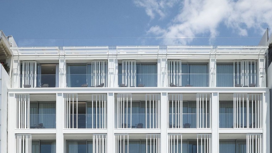 The top floors are a modern addition to the building and has glass railings and extra shading structures to the balconies